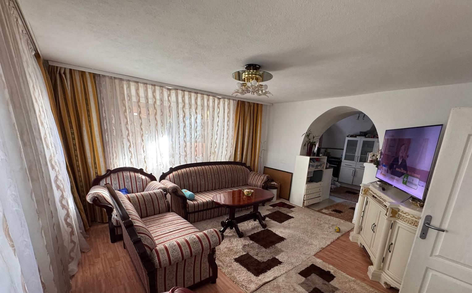 Wohnzimmer der großen Wohnung mit Rundbogendurchgang zur Wohnküche